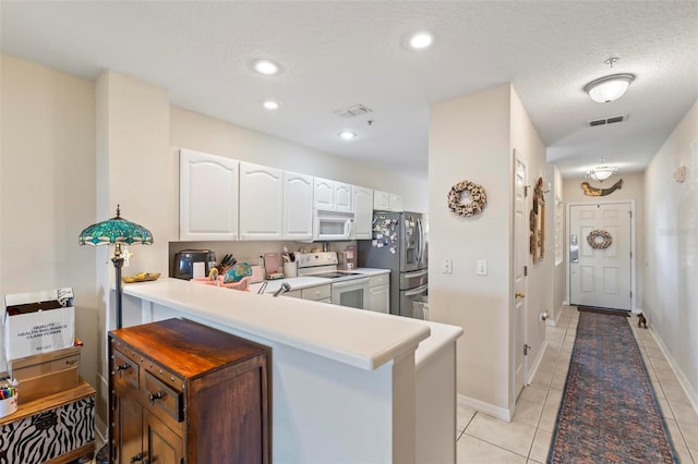 kitchen featuring white cabinets, light tile patterned floors, white appliances, kitchen peninsula, and a textured ceiling