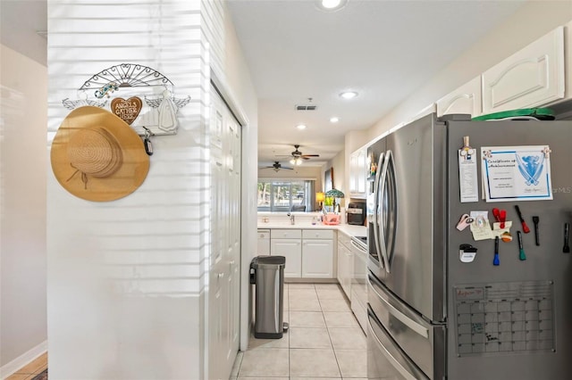 kitchen with light tile patterned floors, white electric range, sink, stainless steel refrigerator with ice dispenser, and white cabinets