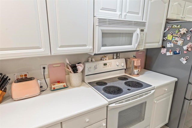 kitchen with white cabinetry and white appliances