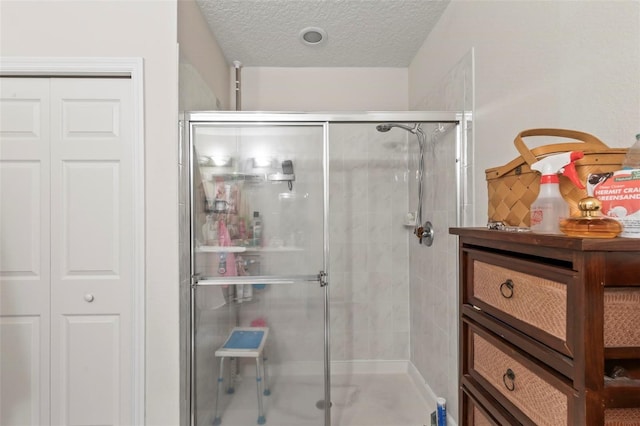 bathroom featuring an enclosed shower and a textured ceiling