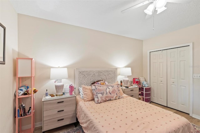 bedroom featuring wood-type flooring, ceiling fan, and a closet