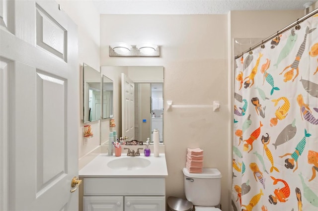 bathroom with vanity, a textured ceiling, toilet, and walk in shower