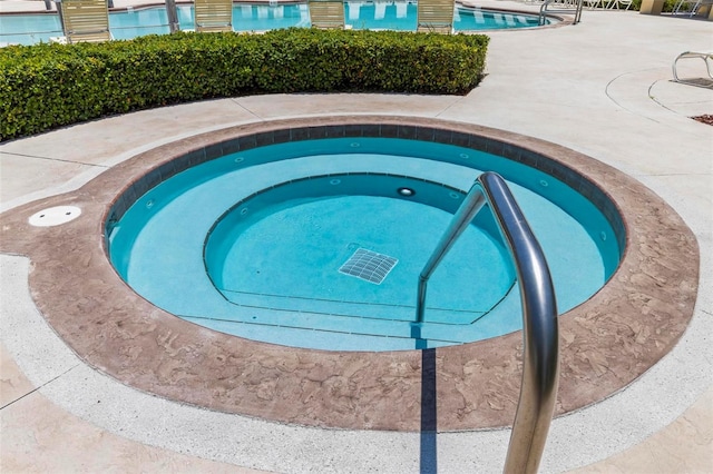 view of pool with a hot tub