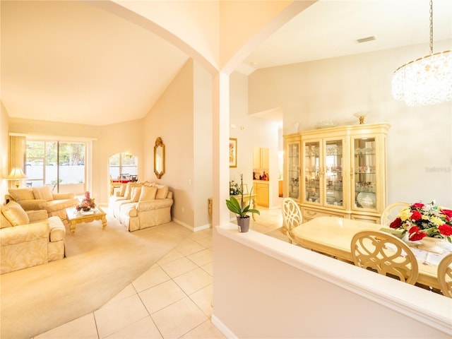 tiled living room with lofted ceiling and a notable chandelier