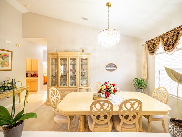 tiled dining space featuring a notable chandelier and vaulted ceiling