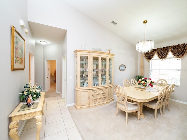 carpeted dining area featuring high vaulted ceiling and a notable chandelier