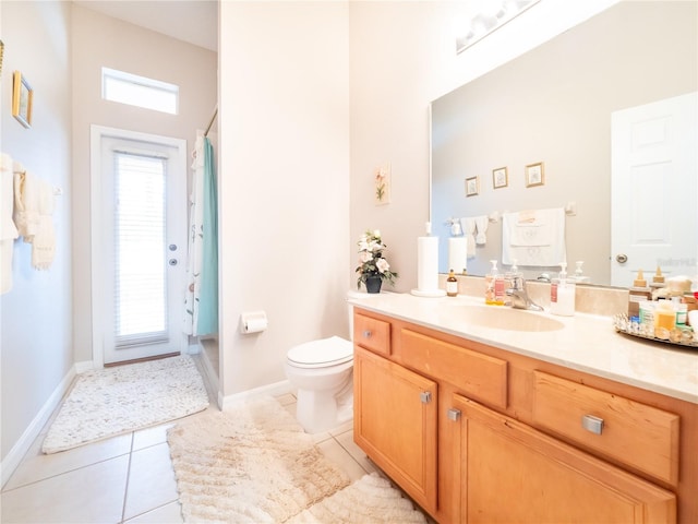 bathroom featuring vanity, a wealth of natural light, tile patterned floors, and toilet