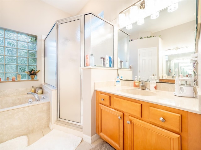 bathroom featuring tile patterned flooring, vanity, and separate shower and tub