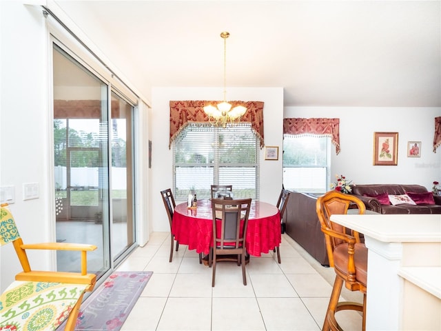 tiled dining area featuring an inviting chandelier and a healthy amount of sunlight