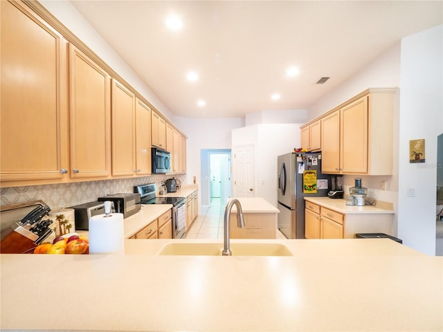 kitchen featuring appliances with stainless steel finishes, sink, decorative backsplash, and light brown cabinets