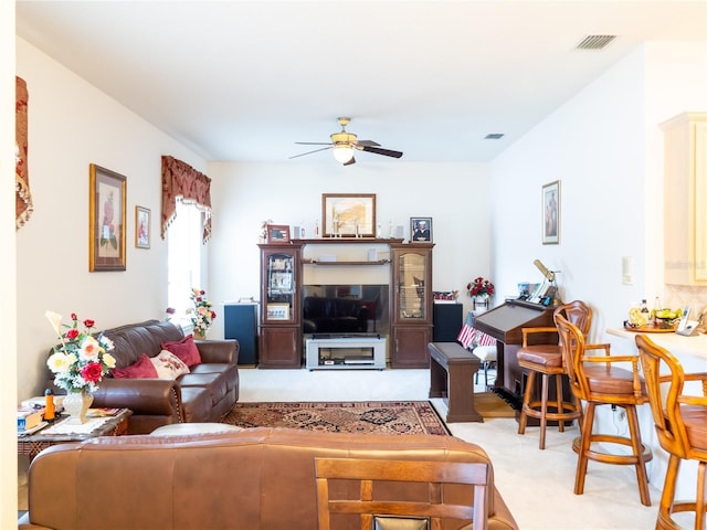 carpeted living room with ceiling fan