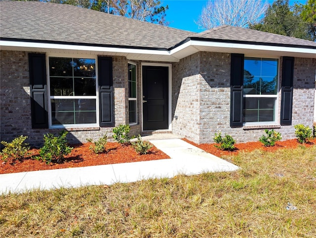 view of exterior entry with a lawn