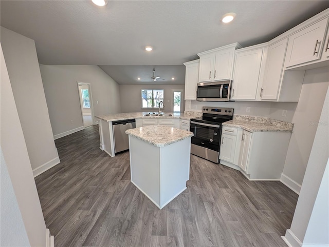 kitchen with sink, white cabinetry, a center island, kitchen peninsula, and stainless steel appliances