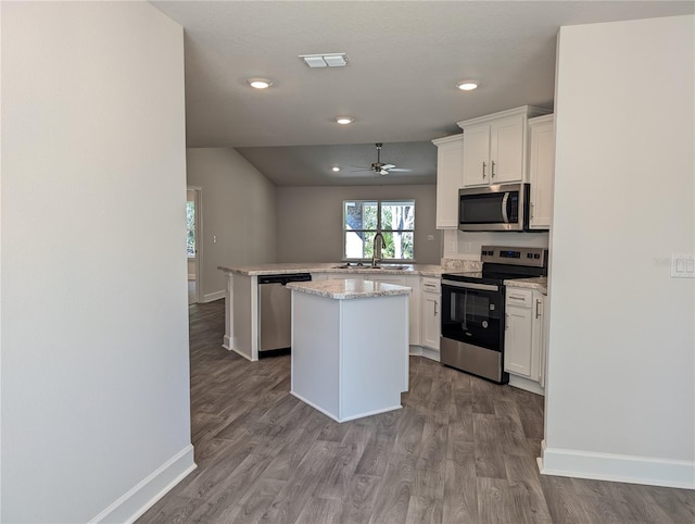 kitchen featuring white cabinetry, sink, stainless steel appliances, and a kitchen island