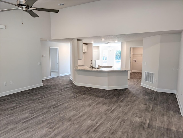 unfurnished living room with sink, high vaulted ceiling, dark hardwood / wood-style floors, and ceiling fan