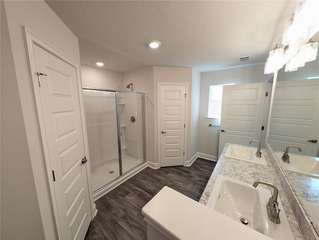 bathroom with vanity, wood-type flooring, a textured ceiling, and walk in shower