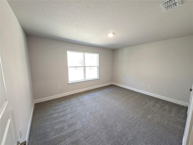 carpeted spare room with a textured ceiling