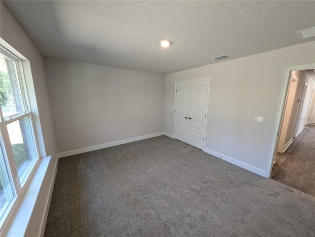 carpeted spare room with a textured ceiling