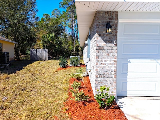 view of yard with a garage and central AC unit