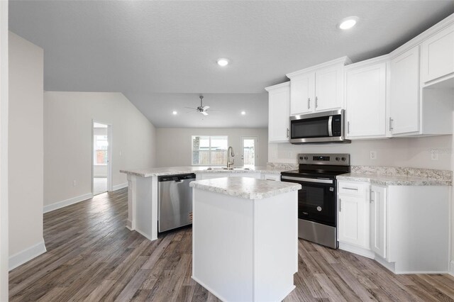 15 Serene Pl, Palm Coast, FL 32164 - kitchen featuring stainless steel appliances, a peninsula, a sink, a ceiling fan, and white cabinets