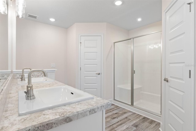 15 Serene Pl, Palm Coast, FL 32164 - bathroom with a shower stall, wood finished floors, recessed lighting, and double vanity