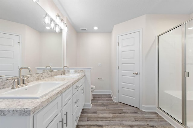 15 Serene Pl, Palm Coast, FL 32164 - bathroom featuring wood finished floors, a shower stall, toilet, baseboards, and double vanity