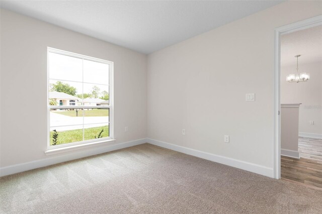 15 Serene Pl, Palm Coast, FL 32164 - empty room with carpet flooring, baseboards, and a chandelier