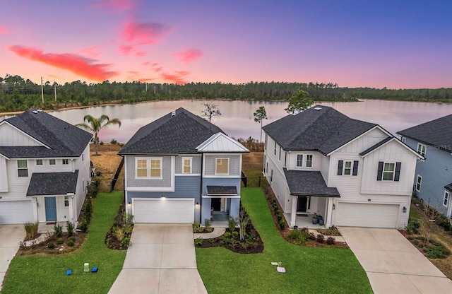 view of front facade with a water view, a garage, and driveway