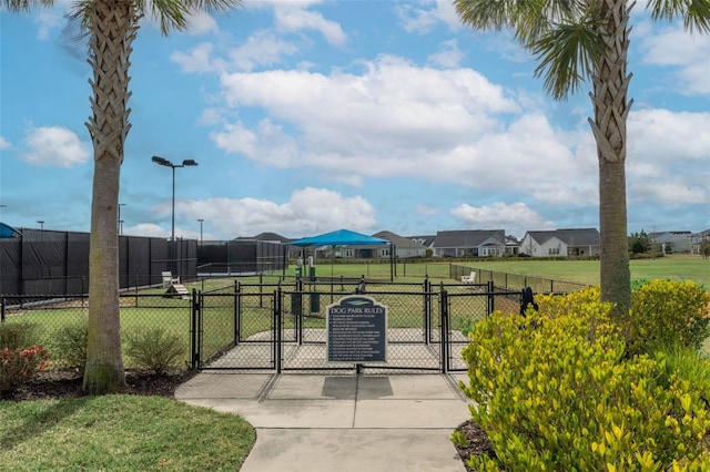 exterior space featuring a residential view, fence, and a gate