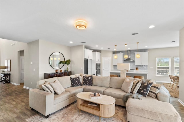 living area with visible vents, recessed lighting, baseboards, and wood finished floors