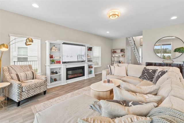 living room featuring stairs, wood finished floors, recessed lighting, and a healthy amount of sunlight