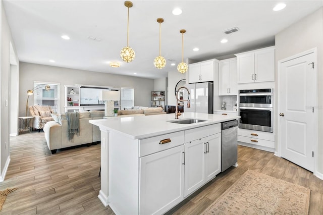 kitchen with visible vents, light wood-type flooring, recessed lighting, stainless steel appliances, and a sink