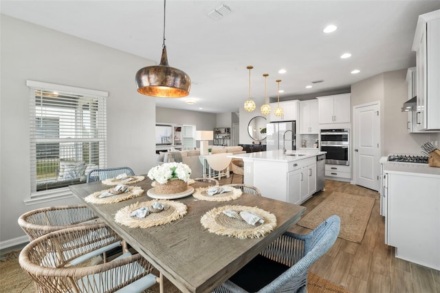 dining area featuring recessed lighting, visible vents, and light wood finished floors