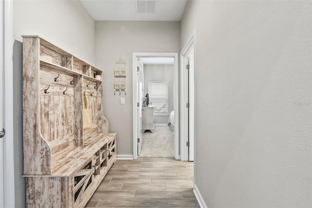 mudroom featuring visible vents, baseboards, and wood tiled floor