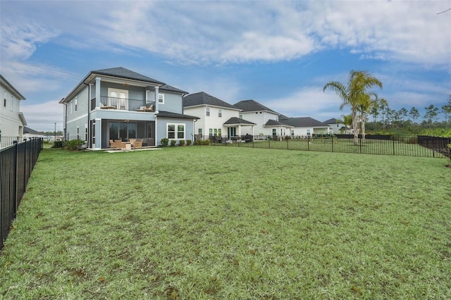 back of property featuring a patio, a balcony, a yard, and a fenced backyard