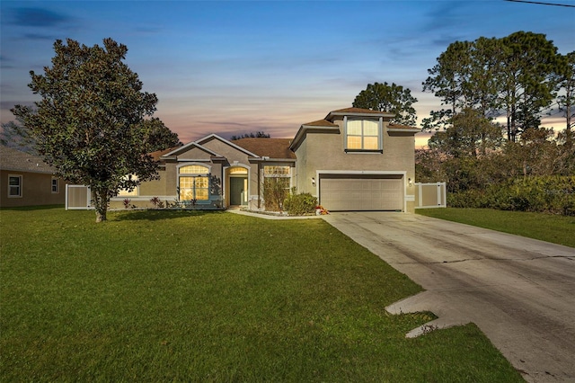 view of front of house featuring a garage and a yard