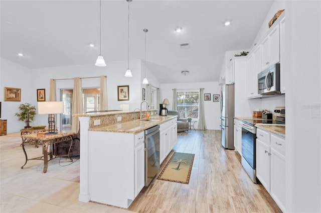 kitchen featuring appliances with stainless steel finishes, pendant lighting, an island with sink, sink, and white cabinets