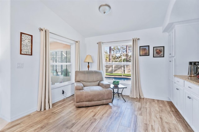 sitting room featuring lofted ceiling, a wealth of natural light, and light hardwood / wood-style flooring