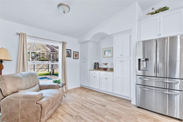 sitting room with vaulted ceiling and light wood-type flooring