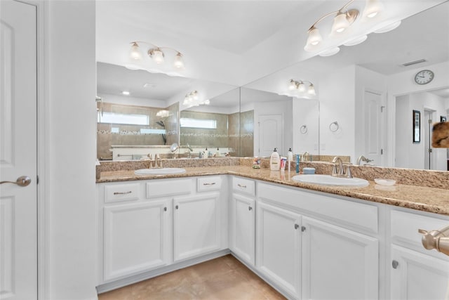 bathroom featuring vanity, tile patterned flooring, and a tile shower