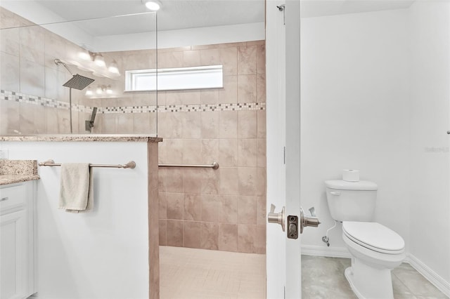 bathroom with tiled shower, vanity, toilet, and tile patterned flooring