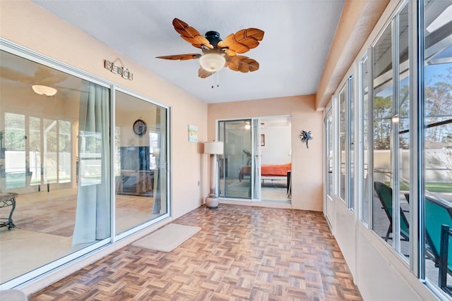 unfurnished sunroom with ceiling fan