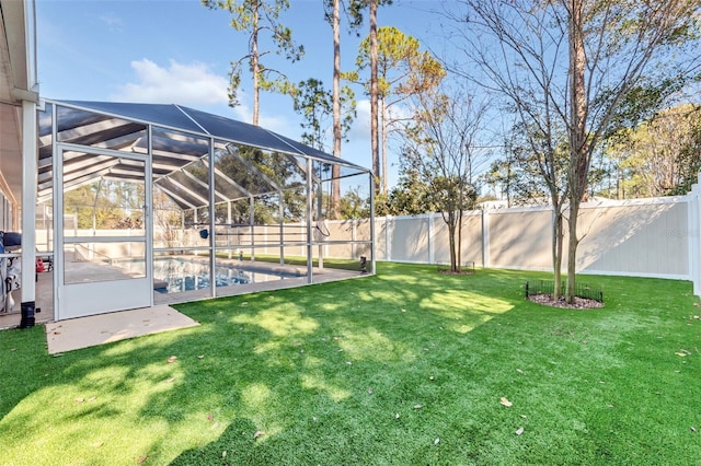 view of yard with a fenced in pool and glass enclosure