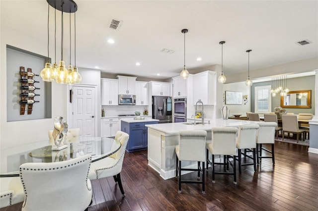 kitchen featuring pendant lighting, stainless steel appliances, a breakfast bar, and kitchen peninsula