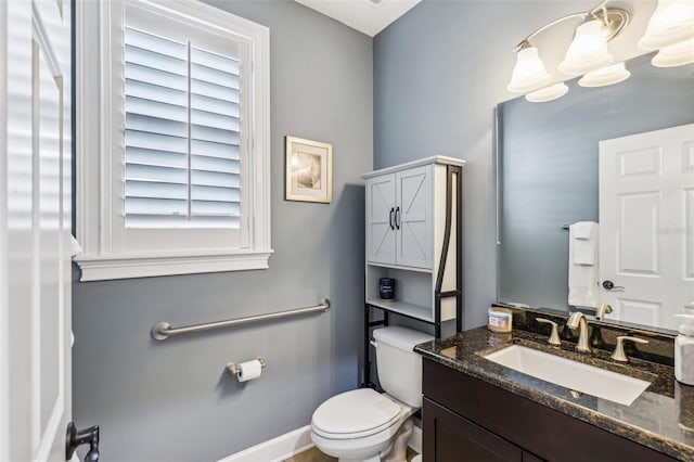 bathroom with vanity, a notable chandelier, and toilet