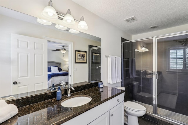 bathroom with vanity, a textured ceiling, toilet, and walk in shower