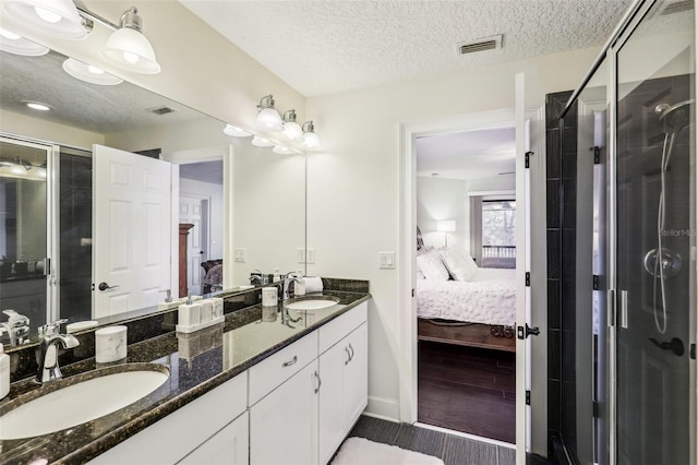 bathroom featuring vanity, hardwood / wood-style floors, a textured ceiling, and walk in shower