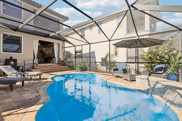 outdoor pool featuring glass enclosure and a patio