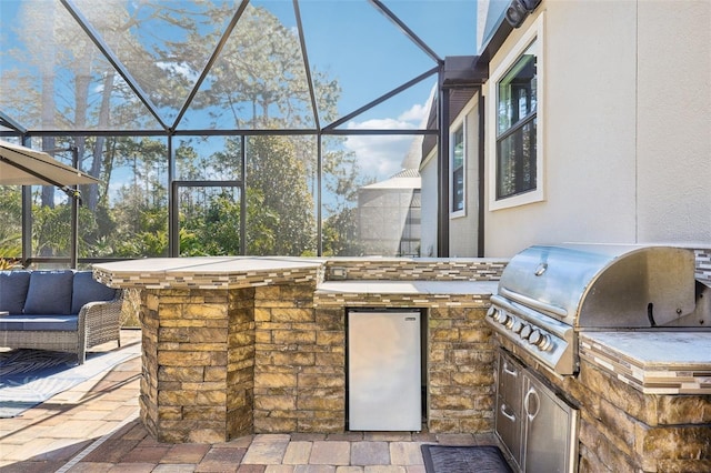 view of patio featuring area for grilling, grilling area, and glass enclosure