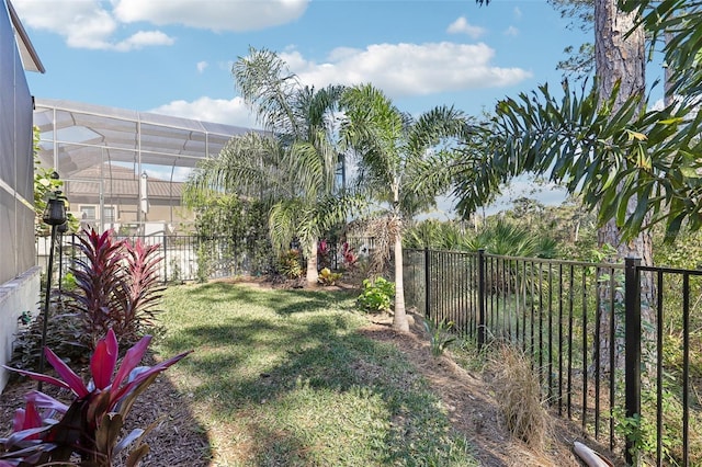 view of yard featuring glass enclosure and a fenced backyard